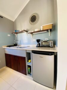 small kitchen with appliances - coffee maker, fridge, cooker, sink, toaster/mini oven